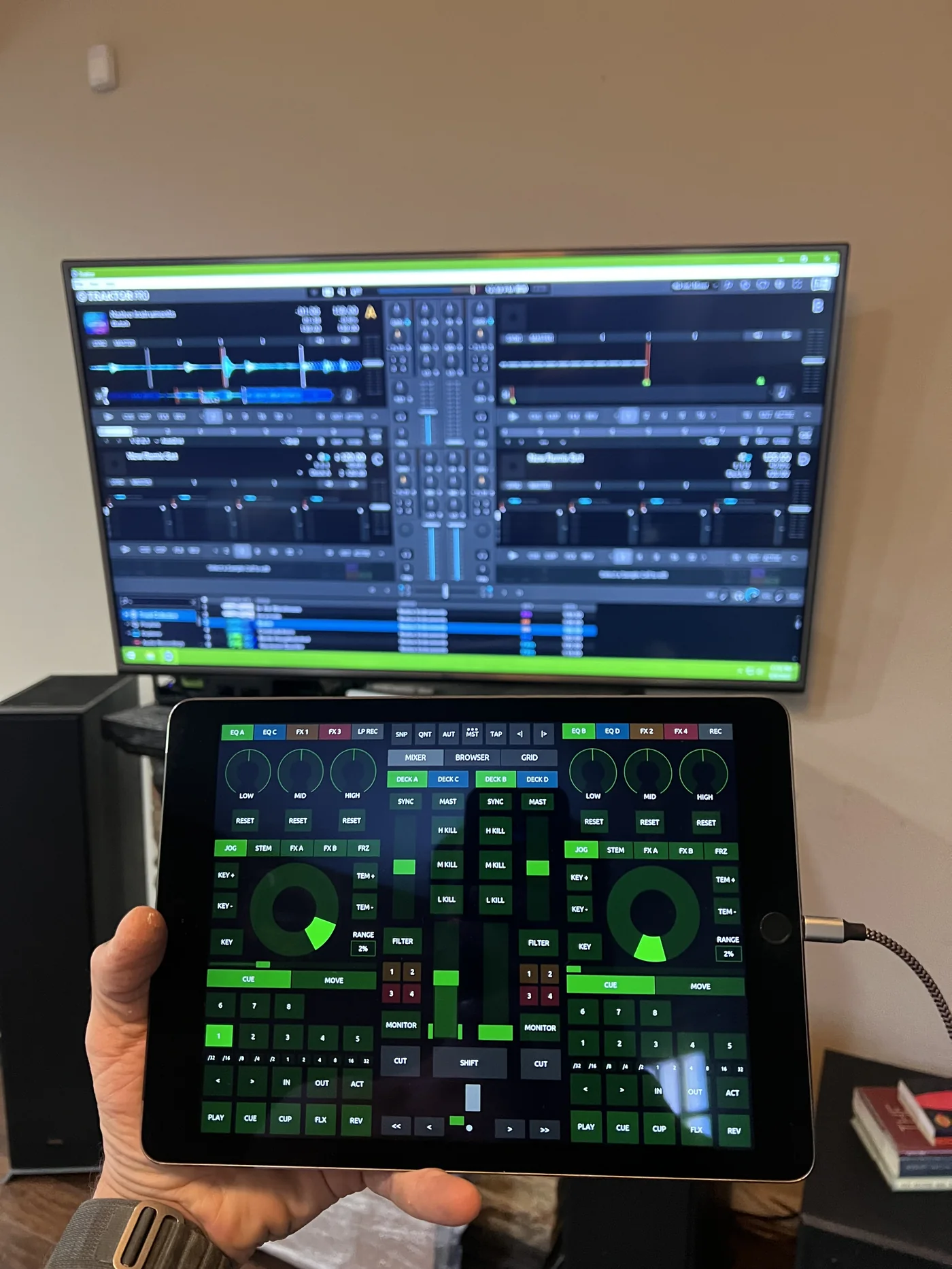Control system interface on a tablet with AV software visible on a display
